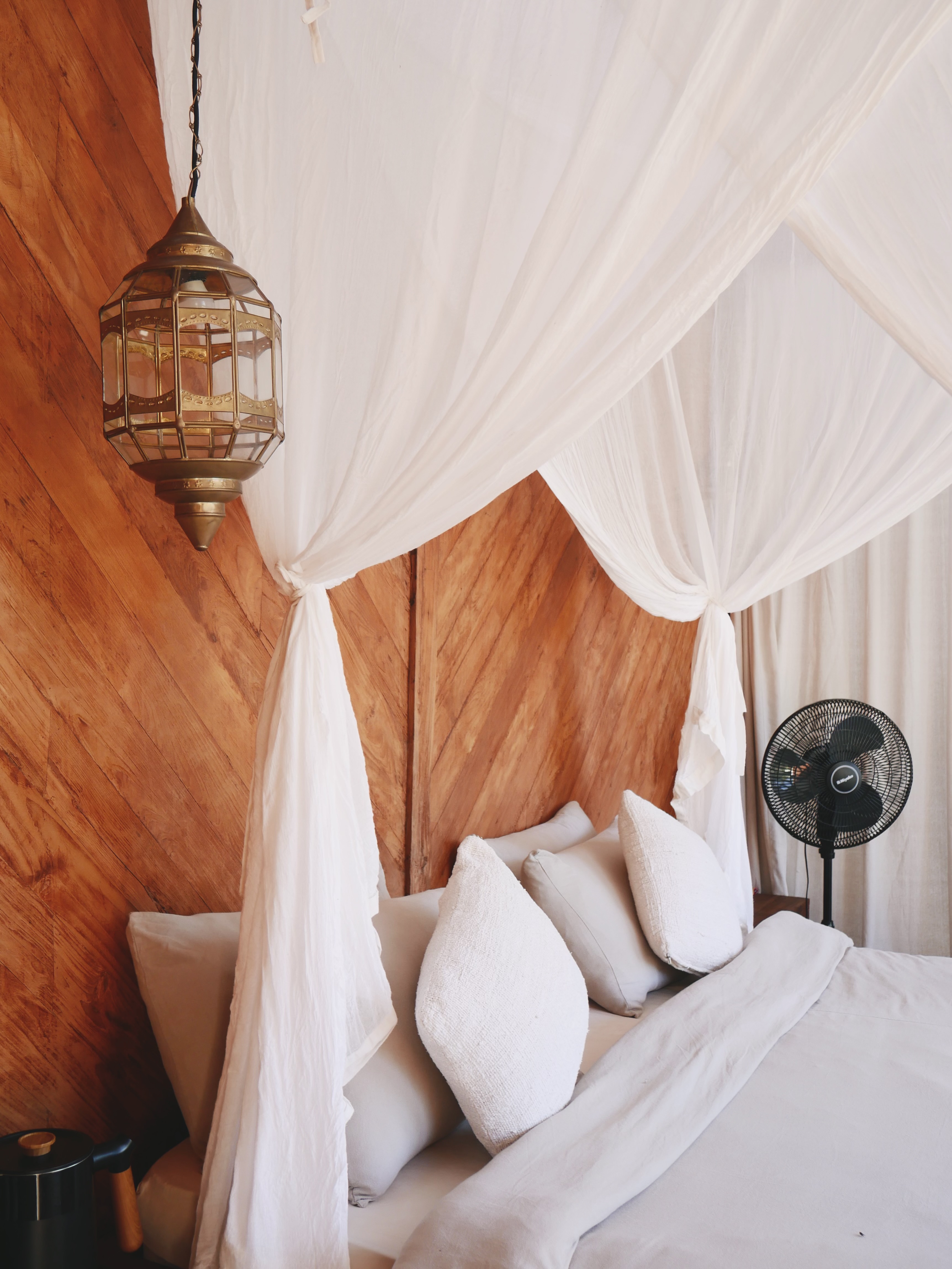 Manggis Villas — king bed with canopy and warm lantern light
